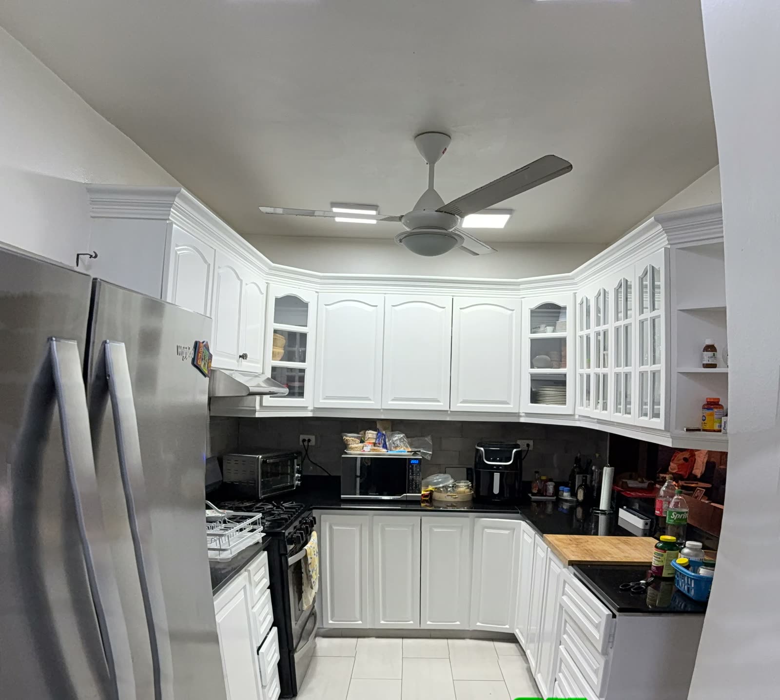 Cocina con gabinetes blancos y electrodomésticos en Torre Don Pedro IV